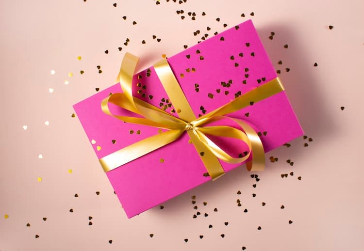 Gift box with gold ribbon on blush pink